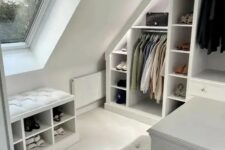 a small white closet with an attic wardrobe with open compartments and drawers, a couple of stools with storage