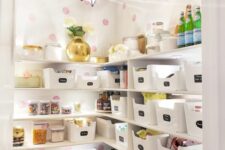 a smart and cool staircase pantry with open shelves, plastic cubbies, lights, printed wallpaper and a star-shaped pendant lamp