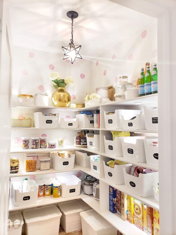a smart and cool staircase pantry with open shelves, plastic cubbies, lights, printed wallpaper and a star-shaped pendant lamp