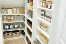 a staircase hiding a pantry with open shelves and cubbies is a cool way to save  a lot of floor space easily