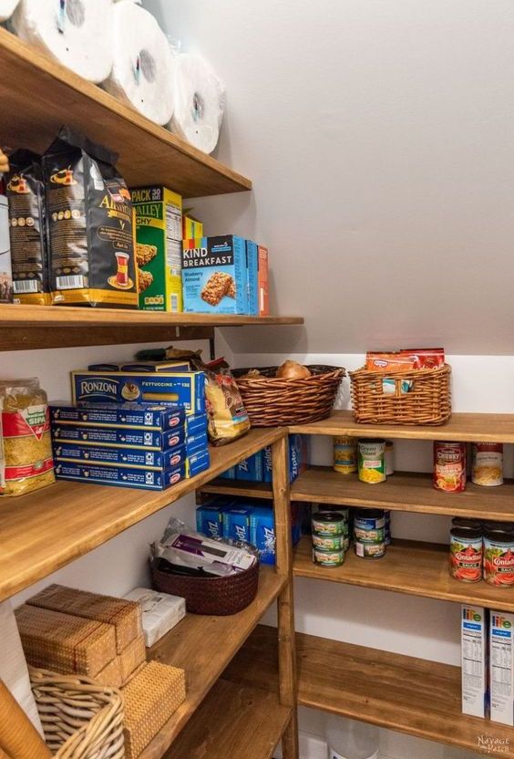 a staircase pantry with built-in stained shelves, baskets and boxes is a cool and smart idea in rustic style