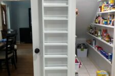 a staircase pantry with open shelves and ledges, with plastic containers and additional light is a smart idea