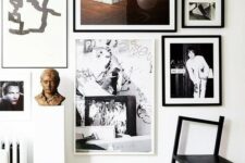 a stylish free form gallery wall with black and white frames and built around a central painting is a chic idea