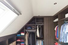 a stylish modern attic closet with dark-stained wardrobes with open compartments and drawers is a lovely space to be in