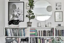 a stylish modern gallery wall with black, brown and silver frames and various types of art plus a mirror