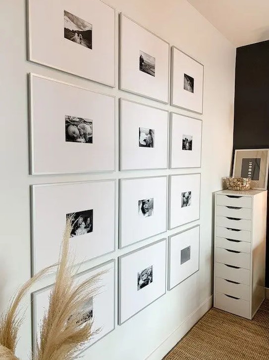a super modern gallery wall with thin silver frames, large matting and small black and white photos