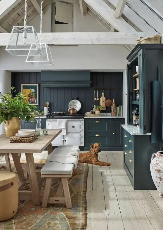 a teal modern farmhouse kitchen with a beadboard backsplash, white stone countertops, a small dining set of wood