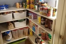 a tiny and well-organized pantry with a built-in shelving unit, plastic crates, additional light is a super smart idea