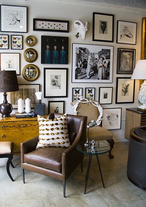 a vintage space with a sideboard, a brown leather chair and a vintage fabric one, an eclectic free form gallery wall