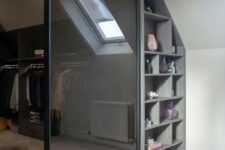 a walk-in closet with a slanted ceiling, with railings, shelves and smoked glass doors is a perfect modern idea