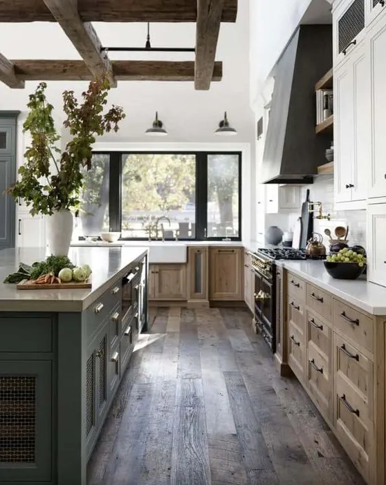 a welcoming modern farmhouse kitchen with stained and white cabinets, a grey kitchen island and a hood, wooden beams