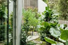 a welcoming side yard with lush greenery and tropical plants plus irregular stone paths is amazing