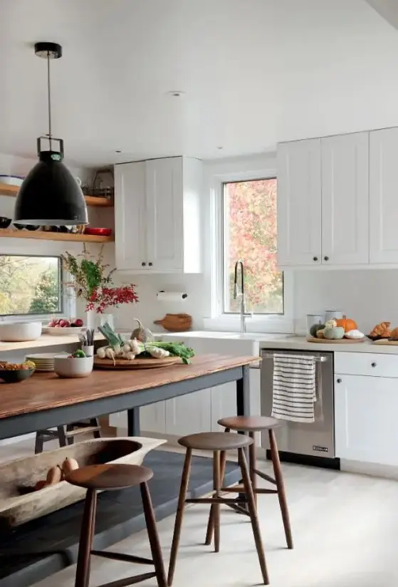 a white modern farmhouse kitchen with shaker cabinets, a soot table and kitchen island, pendant lamps and wooden stools