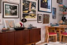 an eclectic space with a stained credenza, a bold pompom rug, some mid-century modern furniture and a bright free form gallery wall