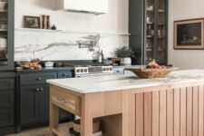 an elevated modern farmhouse kitchen with black cabinets, a white hood, a stained kitchen island, white marble countertops