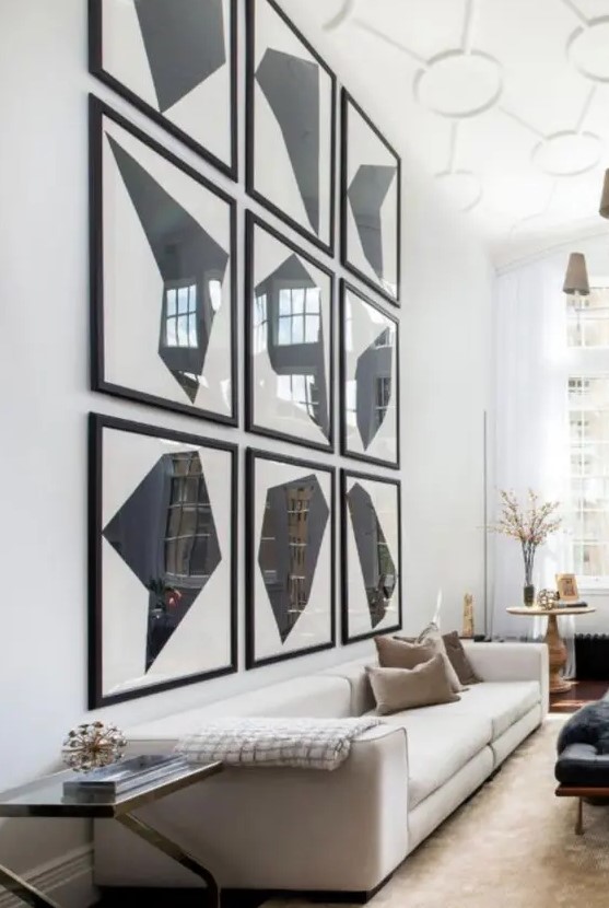 an oversized graphic grid gallery wall takes over the whole space and makes this living room bolder