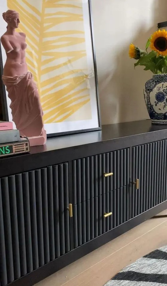 a beautiful black sideboard with black fluted panels and gold handles, with bright and catchy decor is amazing for a modern space
