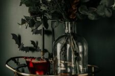 05 a gorgeous spooky bar cart with dark bloody drinks, a bottle with moody and dark blooms and leaves and bats on the wall