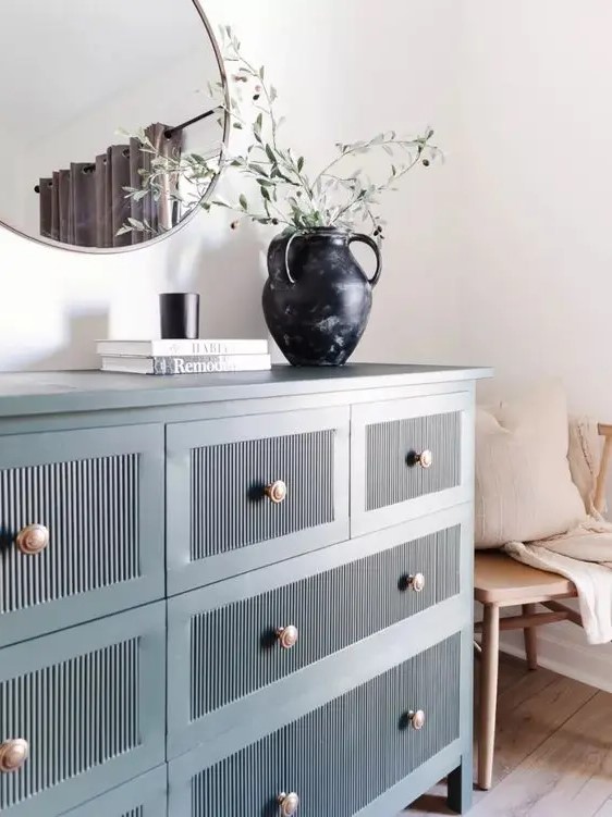 a blue fluted IKEA dresser hack with copper knobs and lovely decor on it is a stylish and chic idea for a modern space
