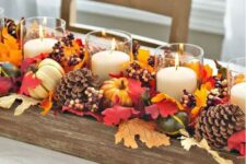 09 a fall centerpiece of a wooden box with pinecones, faux leaves, berries, faux gourds and candles is a bold idea