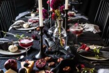 09 a moody and refined Halloween vampire tablescape with black textiles, black candleholders, deep purple blooms and moody food