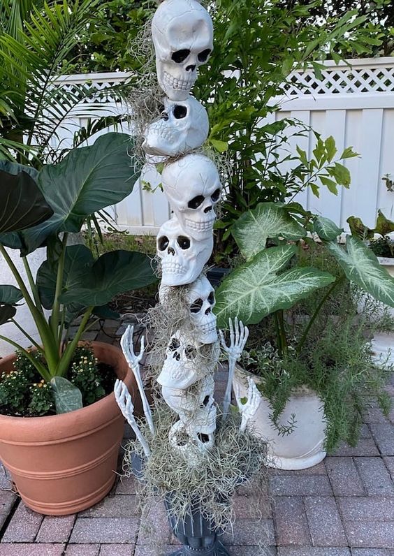 a skull stack with hay and skeleton hands is a cool decoration for Halloween