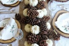 12 a fall table runner of mini pumpkins and large pinecones is a cool rustic decoration to make