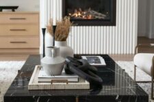 13 a modern fireplace with a fluted surround, a black marble coffee table with decor and neutral furniture