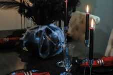 14 a sophisticated vampire Halloween tablescape in red and black, with a black lace runner, burgundy candles and skeleton hand glasses