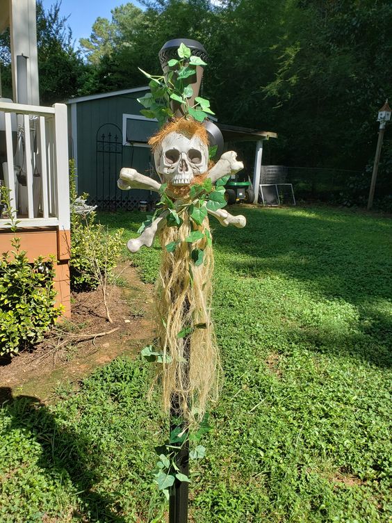 a tropical Halloween decoration of a skull, bones, greenery and some hay is a cool outdoor solution