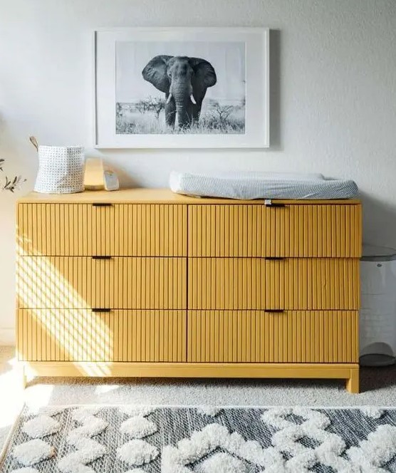 a fluted yellow IKEA Tarva dresser used as a changing table, for placing artwork, candles and lights is a cool idea