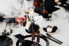 a sophisticated vampire Halloween party table done in black and white, with touches of red, delicious appetizers and drinks