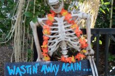 16 a tropical skeleton with a flower necklace and a sign is a lovely and easy Halloween decoraiton you can make