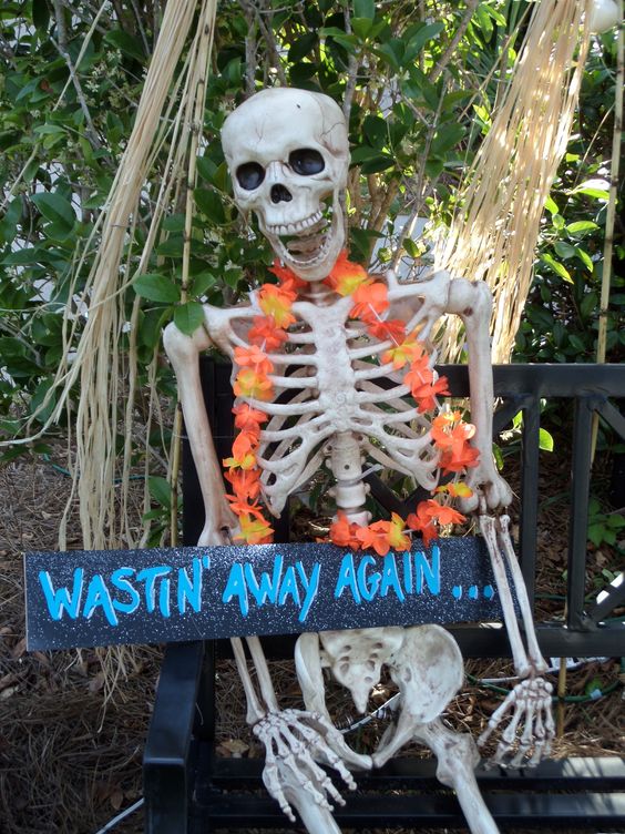 a tropical skeleton with a flower necklace and a sign is a lovely and easy Halloween decoraiton you can make