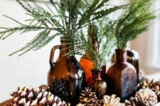 17 a natural fall or winter centerpiece of a bread bowl, pinecones, acorns, apothecary glass bottles and greenery