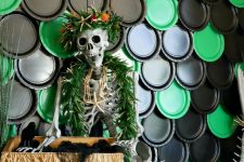 18 indoor Halloween decor with black and green plastic dishes, a mermaid skeleton in a necklace and a chest with stuff