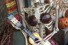 19 a lady skeleton with a guitar is a whimsy Halloween decor idea, it will fit both indoors and outdoors