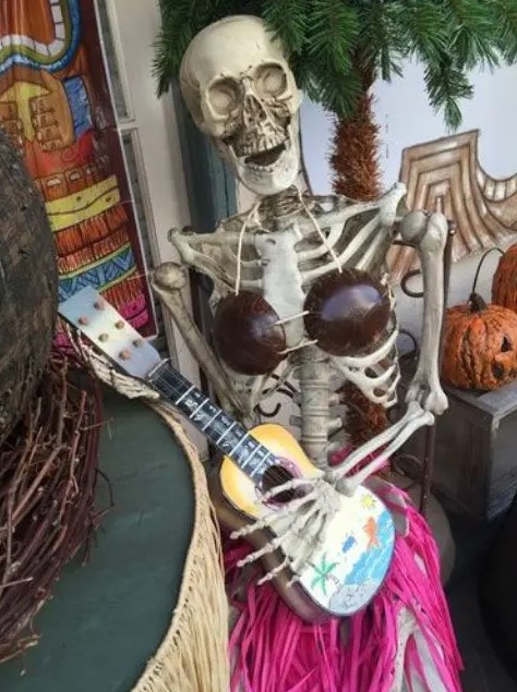 a lady skeleton with a guitar is a whimsy Halloween decor idea, it will fit both indoors and outdoors