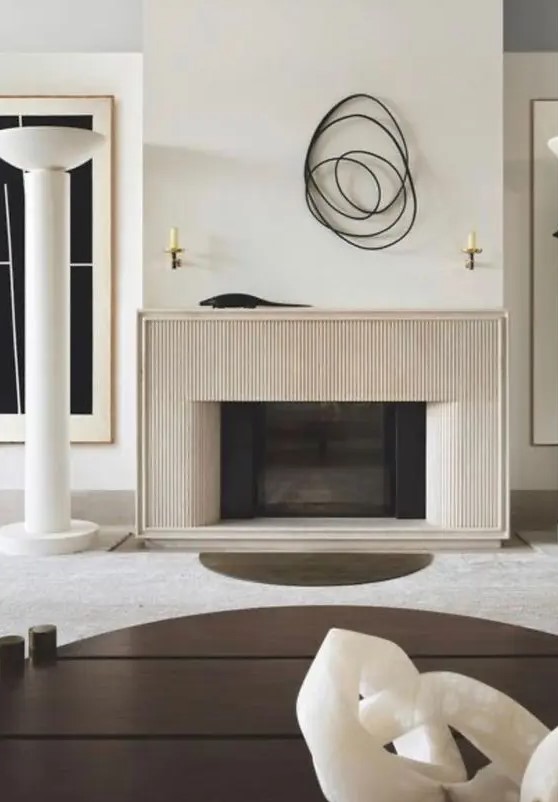 a refined neutral contemporary space with a fluted surround fireplace, a printed rug, a coffee table and some abstract decor