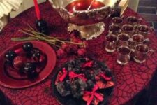 19 an elegant punch table with bloody punch and bloody apples, black and red candles