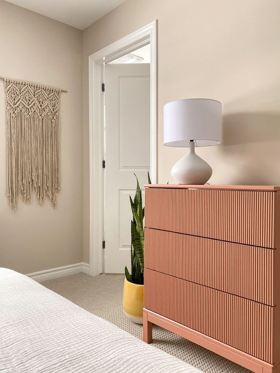 a lovely pink fluted dresser as a color touch to the neutral bedroom and a lovely piece with a trendy feel