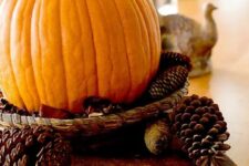 20 a simple fall centerpiece of a wood board, pinecones and a pumpkin in a woven tray is easy to make