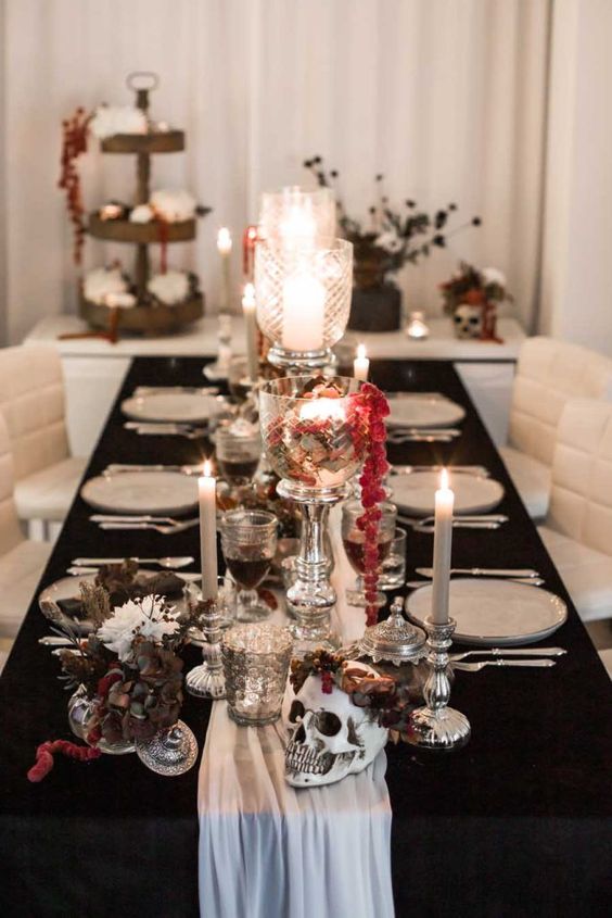 a beautiful and refined Halloween tablescape with dark and white blooms, a skull in a flower crown, some amaranthus