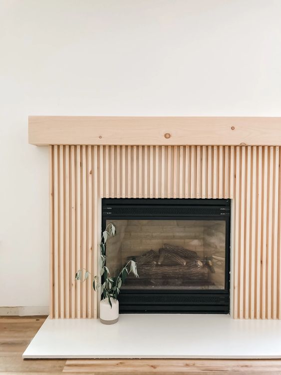 a built-in fireplace with a fluted surround and a matching light-stained mantel is a cool idea
