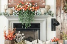 22 a lush fall mantel with pale greenery, faux pumpkins, gorgeous florals and cascading greenery, fall leaves and cotton in buckets and a fall sign