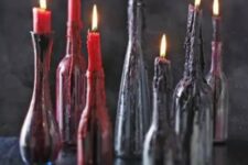 22 bottles with candle of several shade sof blood look like it is dripping down the bottles