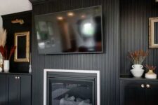23 a catchy living room with a black fluted wall and a matching fireplace surround, cabinetry, lovely decor is all cool