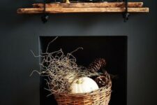 23 elegant fireplace styling with a basket with twigs, pinecones and a pumpkin and a rough mantel with candles
