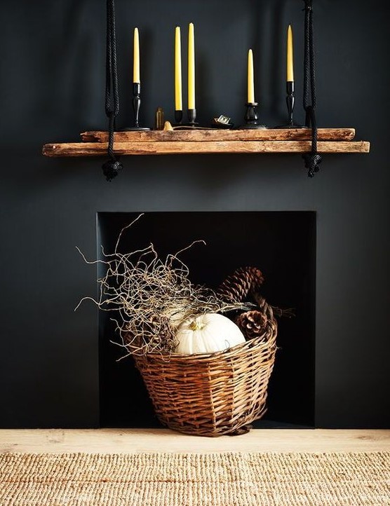 elegant fireplace styling with a basket with twigs, pinecones and a pumpkin and a rough mantel with candles