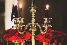 23 red roses pair up beautifully with deep purple and black candles in a gold candelabra for a Halloween decoration